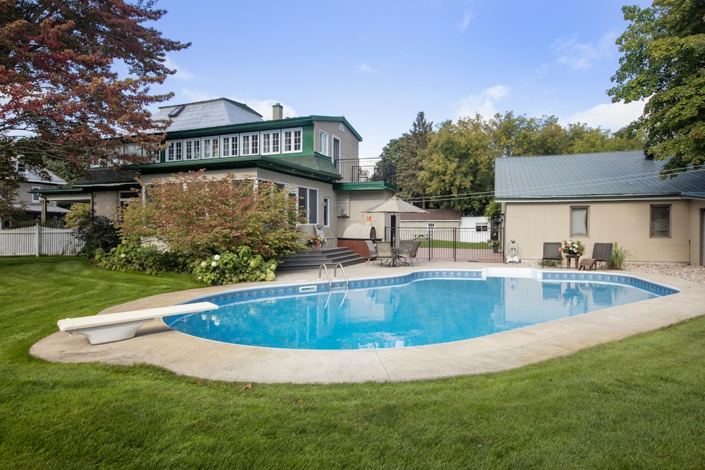 Vue de la piscine creusée et de la maison depuis le jardin