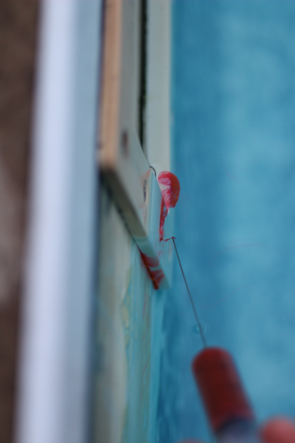 Application de colorant rouge à la seringue près d’une pièce de la piscine